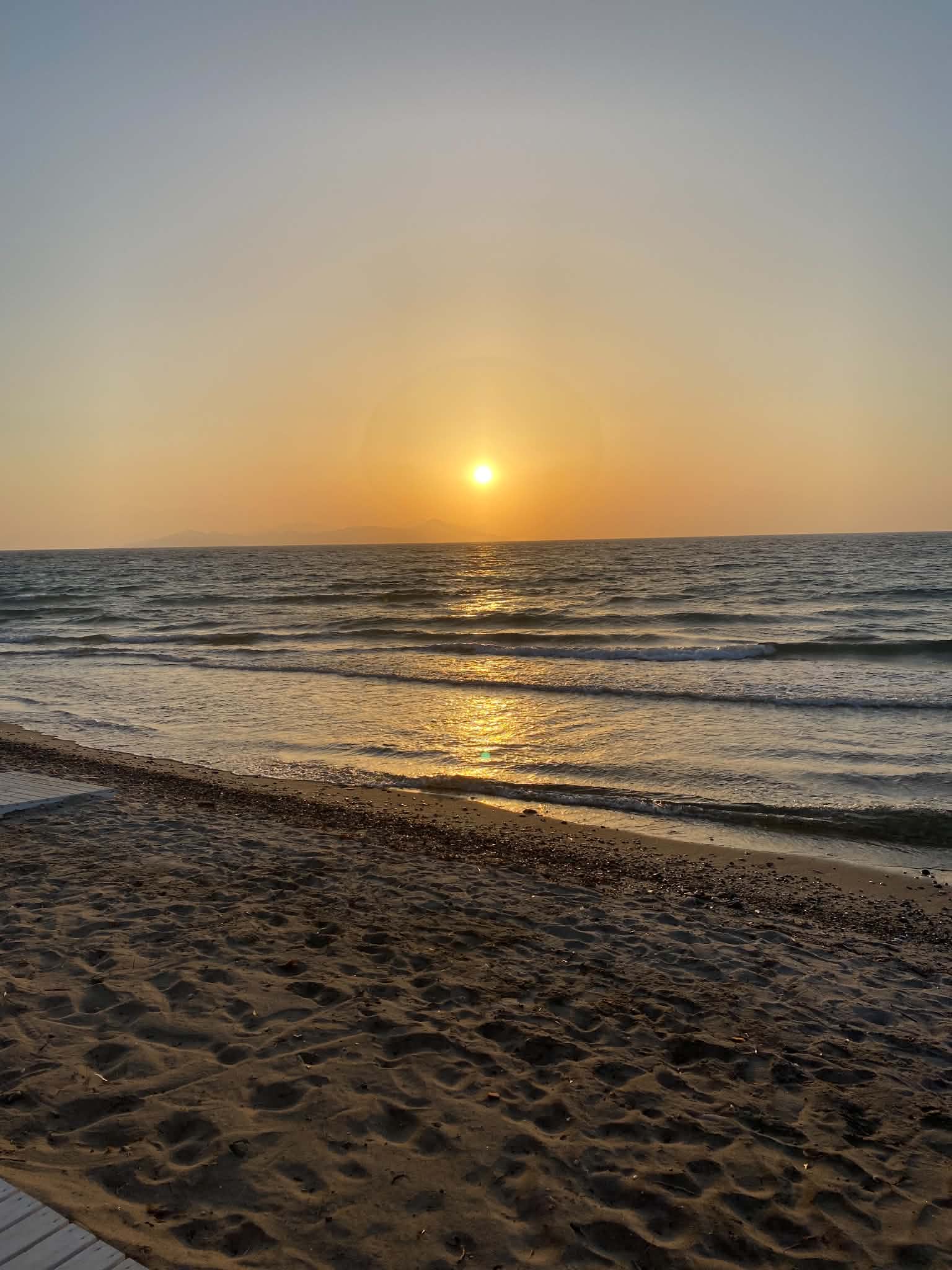 Warme zonsondergang boven de zee en het strand